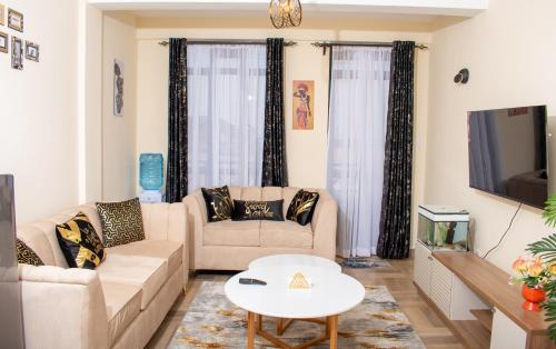 纳库鲁Luxury 1Br Apartment with Secure Parking & Lift Nakuru的客厅配有两张沙发和一台电视机