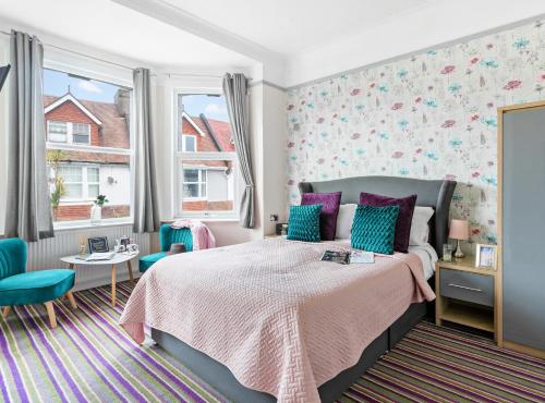 佩恩顿舍伍德旅馆的一间卧室配有一张带紫色和蓝色枕头的床