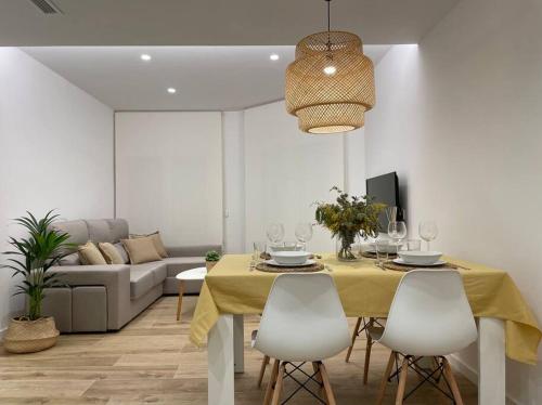 帕拉莫斯Apartamento nuevo céntrico frente al mar en Palamós的用餐室配有黄色的桌子和椅子