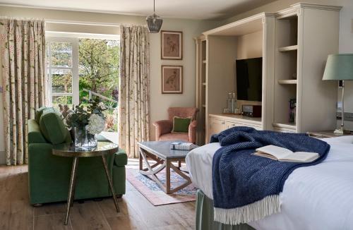 博利厄蒙塔古阿姆斯酒店的一间卧室配有一张床、一把椅子和电视