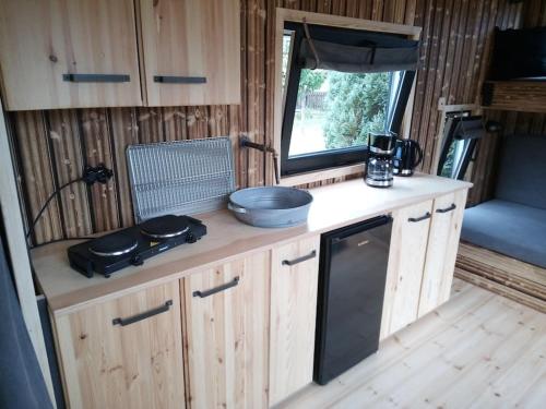 阿佩勒恩Tiny House Calido的厨房配有木制橱柜和窗户。