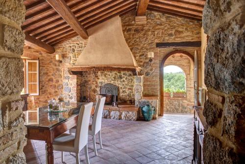 圣吉米纳诺安缇卡迪莫拉酒店的厨房配有桌子和石墙