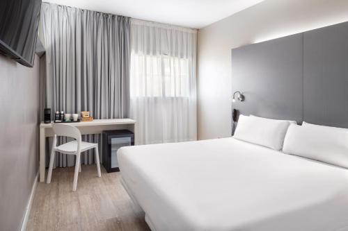 莫勒山谷B&B HOTEL Barcelona Mollet的配有一张床和一张书桌的酒店客房