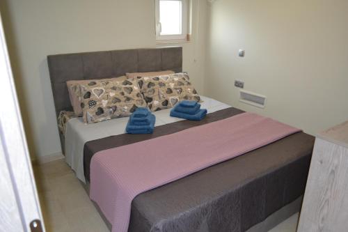 阿纳维索斯Stergiou Luxury Apartments with shared pool的一间卧室配有一张带蓝色毛巾的床