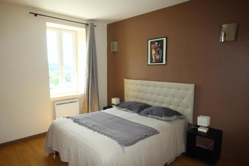 里摩日Le coudert的一间卧室设有一张大床和一个窗户。