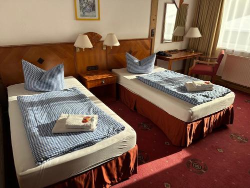 TettauHotel Söllner的酒店客房,设有两张床和镜子