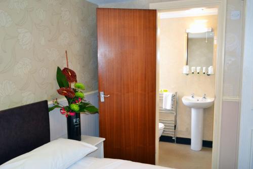 布莱克浦林德内酒店的一间卧室设有通往水槽的木门