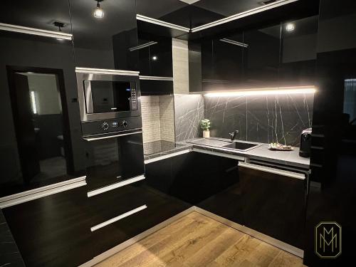 克卢日-纳波卡MM Residence的黑色厨房配有水槽和微波炉