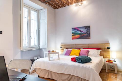 都灵Apple House al Duomo by Wonderful Italy的一间卧室配有一张带色彩缤纷枕头的大床