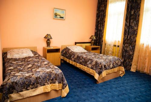 克列缅丘格Avalon的酒店客房,设有两张床,铺有蓝色地毯。