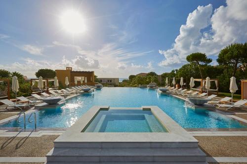 Romanu威斯汀克斯塔纳瓦里诺酒店的一个带躺椅的大型游泳池和一个游泳池