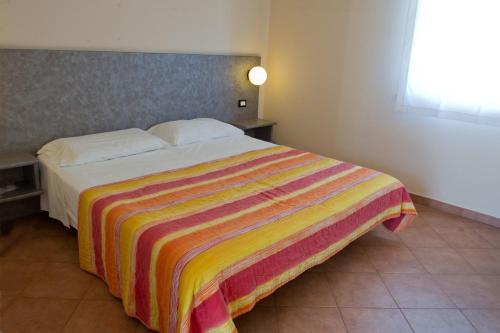 拉文纳Autohotel Ravenna的一间卧室配有一张带彩色毯子的床