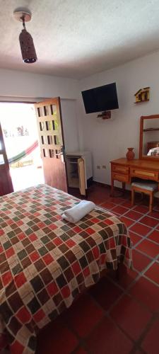 La MiraPosada Las Ross的一间卧室配有一张床和一台平面电视
