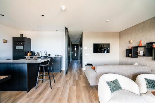坎珀兰Luxe appartement in haven Marina Kamperland - 2 badkamers的厨房以及带沙发和桌子的客厅。