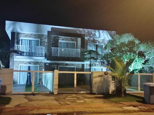 弗洛里亚诺波利斯Moradas do Campeche CSABC的一座白色的大建筑,晚上有门廊