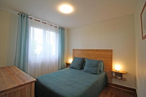 CouzeixLe magnolia的一间卧室配有一张带蓝色床单的床和一扇窗户。