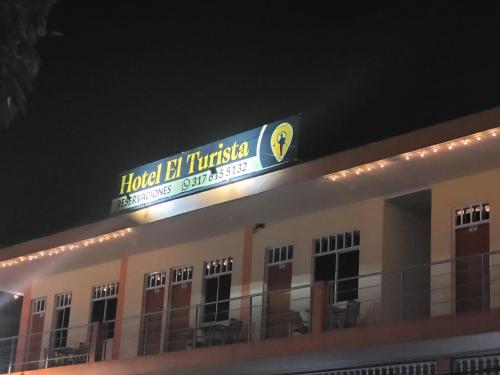 弗洛伦西亚Hotel el Turista的夜间建筑物顶部的标志