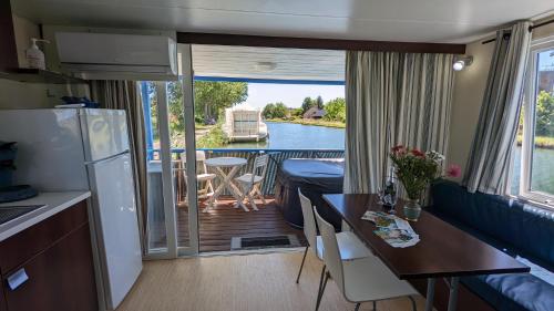 圣让德洛讷Cottage flottant jacuzzi privé en option gamme supérieure的一间厨房和享有船只景致的用餐室
