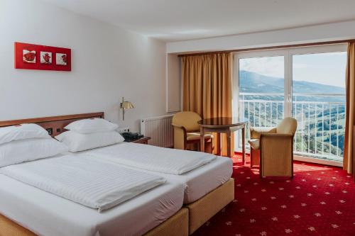 PreblHotel Friesacherhof的酒店客房设有一张床和一个大窗户