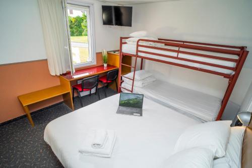 波城Quick Palace Pau Zénith的酒店客房设有两张双层床和一张书桌。