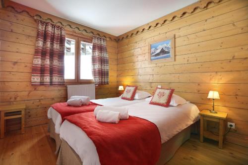 蒂涅Tignes-8-10 personnes-4 chambres-parking的一间带两张床铺的卧室,位于带木墙的房间内