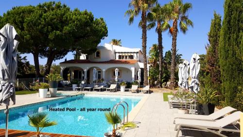 珀彻斯Casa Bela Moura, Boutique Hotel & Wine的一座别墅,设有游泳池和棕榈树