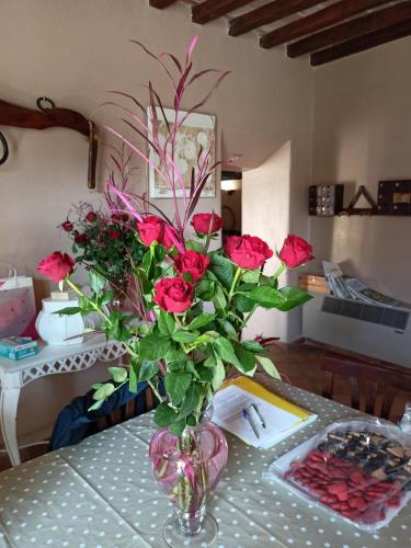 FiaiolaLu Renge的一张桌子上满是红玫瑰的花瓶