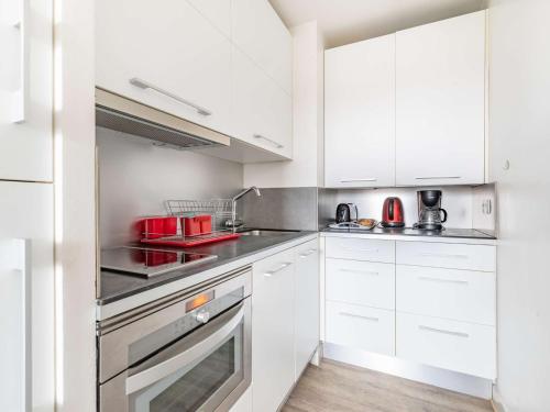 昂代Studio Hendaye, 1 pièce, 3 personnes - FR-1-2-304的厨房配有白色橱柜和红色用具
