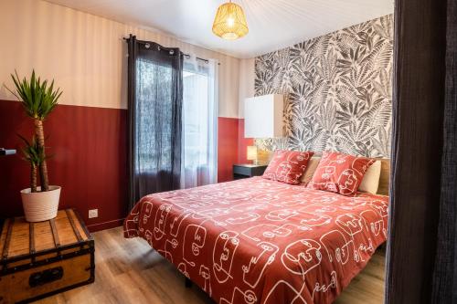 阿维尼翁Jolie Maison de ville proche centre-ville的一间卧室配有一张带红色和白色床罩的床。