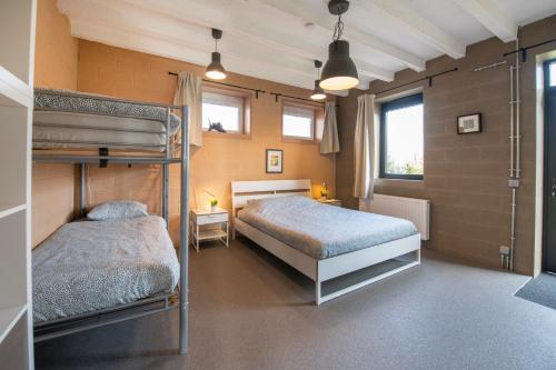HeersDE SMISHOEVE 4 vakantiewoningen met speelruimte, dieren en wellness的一间带两张双层床的卧室和两个窗户
