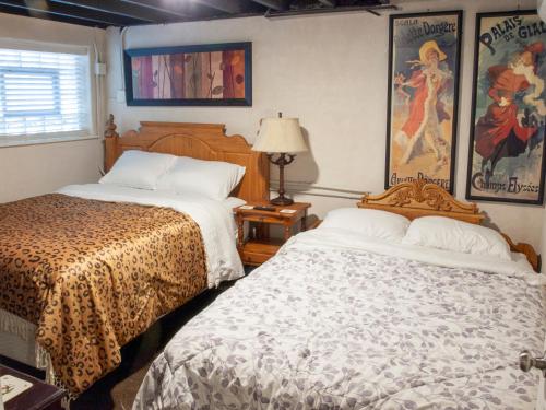 芝加哥Bootlegger House Sleeps 10-20 Free TV & Parking的一间卧室设有两张床、一盏灯和一扇窗户。