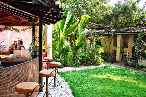 安君纳"Sunny Cow" Village Villa的庭院设有带凳子的庭院和花园