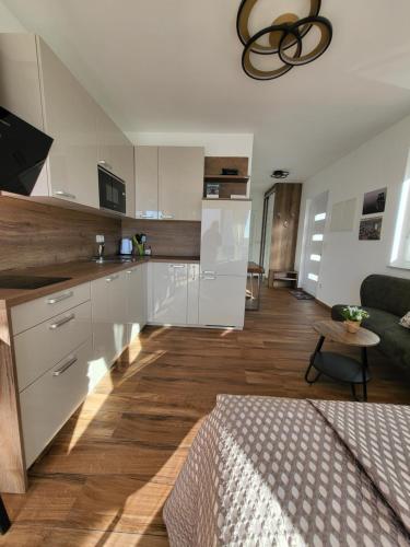 伊穆尼Studio apartman Pegi的一间带白色橱柜的厨房和一间客厅