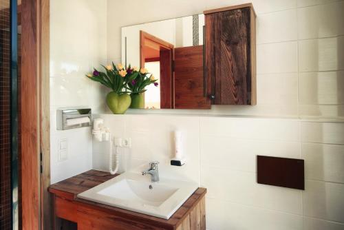 波金格乔治路德维希马丁旅馆的浴室水槽,配有镜子和花瓶