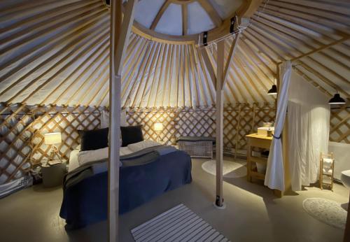 HaukadalurNáttúra Yurtel的蒙古包内一间卧室,配有一张天蓬床