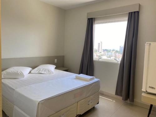乌贝兰迪亚San Martin Hotel的一间卧室设有一张床和一个大窗户