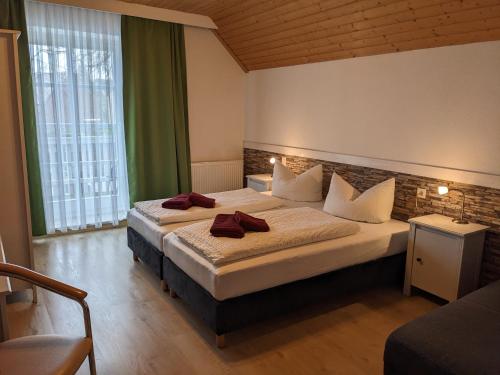 KlödenPension Auf der Tenne的酒店客房,配有两张带红色毛巾的床