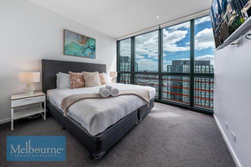 墨尔本墨尔本私人公寓 - 滨海港区科林斯街的一间卧室设有一张床和一个大窗户