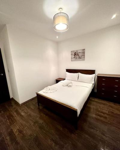 伦敦Alarabi Apartments-Peckham的一间卧室配有一张带白色床单的大床