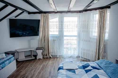 阿雷富LaBebe - Vidraru的一间卧室设有一张床和一个大窗户