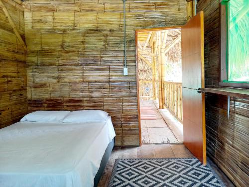 伯里塔卡Casa Estuario的卧室配有木墙内的一张床