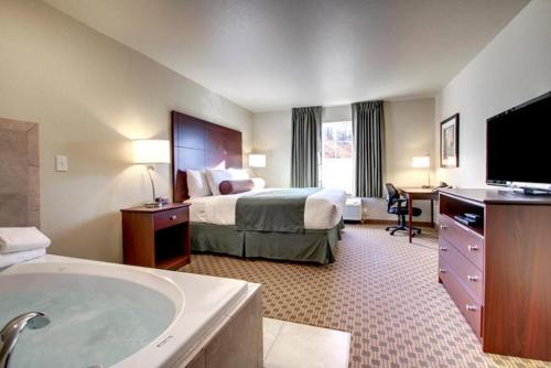 KnoxvilleCobblestone Hotel & Suites - Knoxville的酒店客房配有一张床和浴缸。
