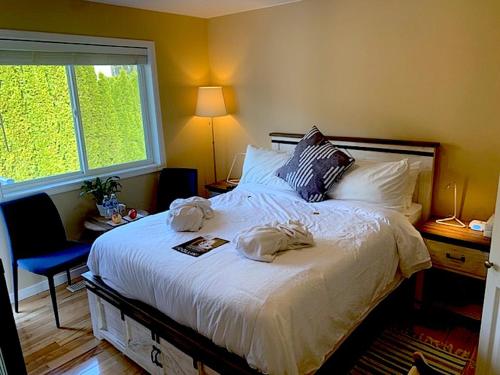 West KelownaSalish B&B and Spa的一间卧室配有一张大床和两条毛巾