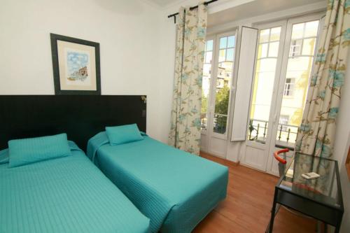 里斯本若昂酒店的一间卧室设有两张单人床和一个窗户。