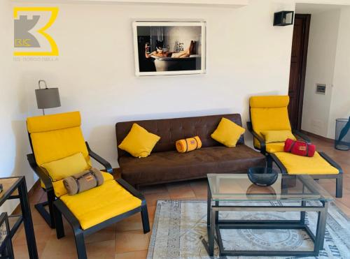 CandeloBB Bis的客厅配有黄色椅子和棕色沙发