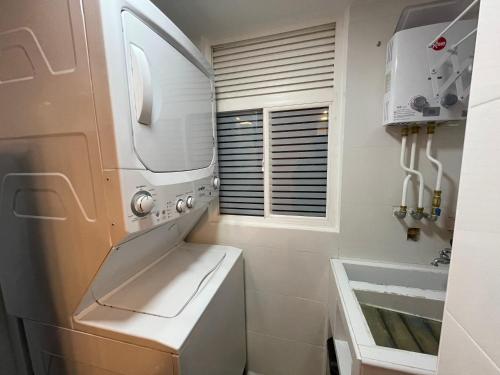 卡利Apartamento en Cali Inn tropical CLO的厨房配有洗衣机、烘干机和水槽