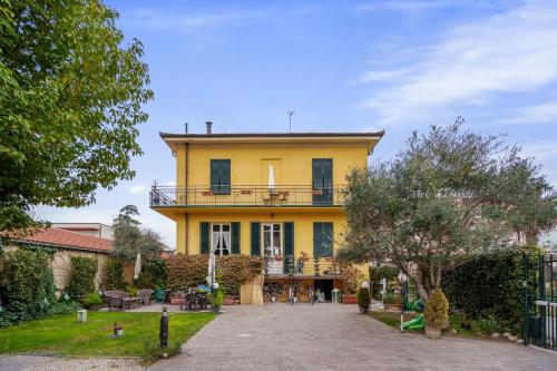 卢卡Villa San Donato B&B的黄色房子的顶部设有阳台