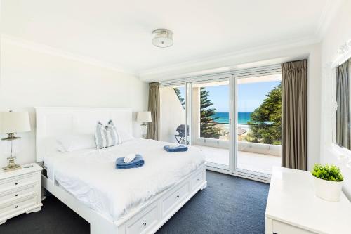 悉尼Luxury Manly Beachfront Apartment的白色的卧室设有一张大床和一个大窗户