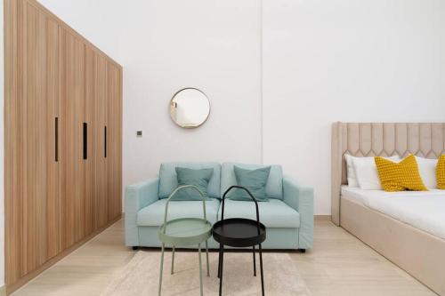 迪拜Nice and cozy Studio Elysée 2 in JVC - Dubai的客厅配有蓝色的沙发和两把椅子