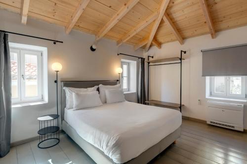 埃尔莫波利斯The Ten Syros的卧室配有白色的床和2扇窗户。